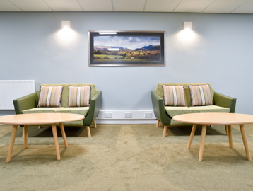 Communal seating and tables inside Acre Court with blue painted walls