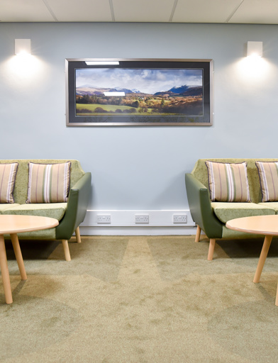 Communal seating and tables inside Acre Court with blue painted walls