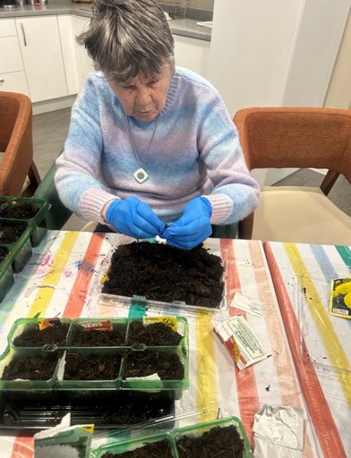 Resident Janet planting seeds 