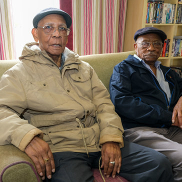 Two brothers who are residents sitting down in a living room