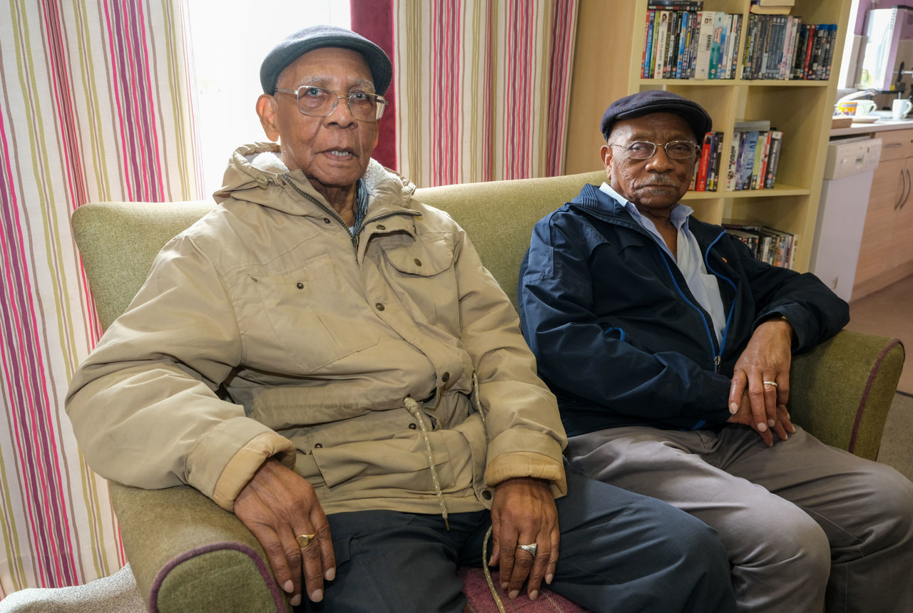 Two brothers who are residents sitting down in a living room
