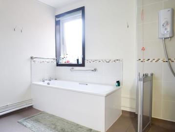 An assisted bathroom with bath and walk-in shower at Alan Hilton Court