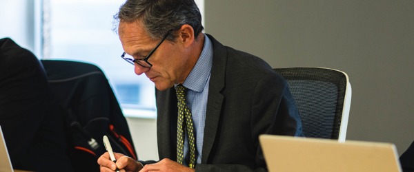 Chief Executive, Bruce Moore, writes in a notebook during a meeting 