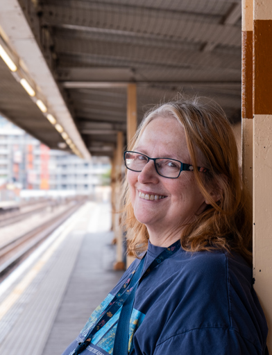 Jane, a resident at Minterne Apartments smiling into camera waiting for the underground 