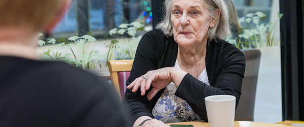 An Extra Care residents talks to a Housing 21 manager at a table