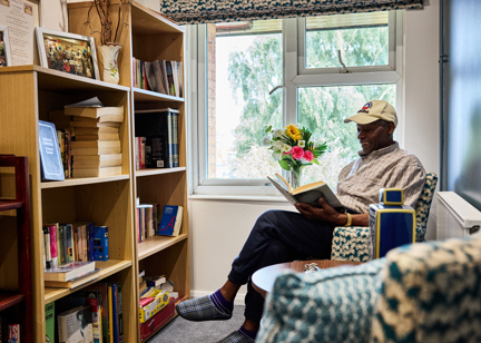 Resident sitting down reading a book