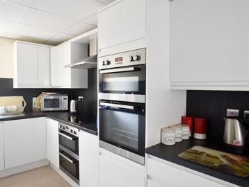 A modern, white kitchen in an apartment