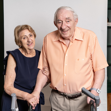 A couple stood together for studio-style photoshoot in a communal lounge