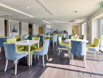 Inside Filey Fields restaurant featuring blue and yellow chairs around dining tables