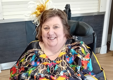 Lady in colourful dress smiling at the camera