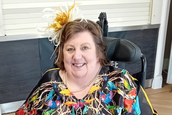 Lady in colourful dress smiling at the camera 