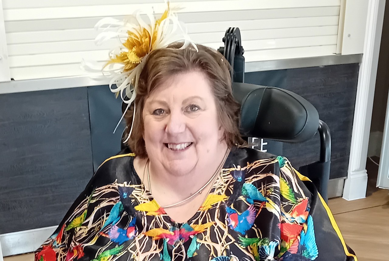 Lady in colourful dress smiling at the camera 