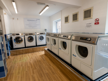 Large laundry room with a combination of washing machines and dryers