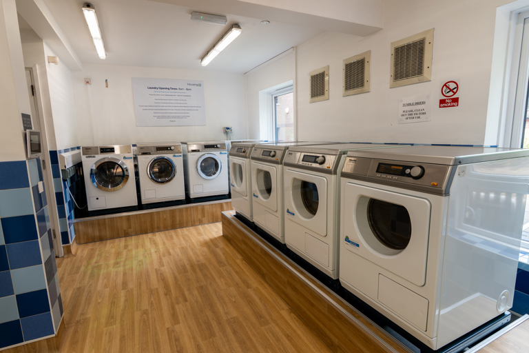 Large laundry room with a combination of washing machines and dryers