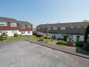 Front of the apartments and parking area with grassed frontage
