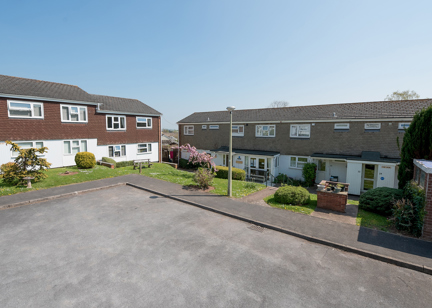 Front of the apartments and parking area with grassed frontage