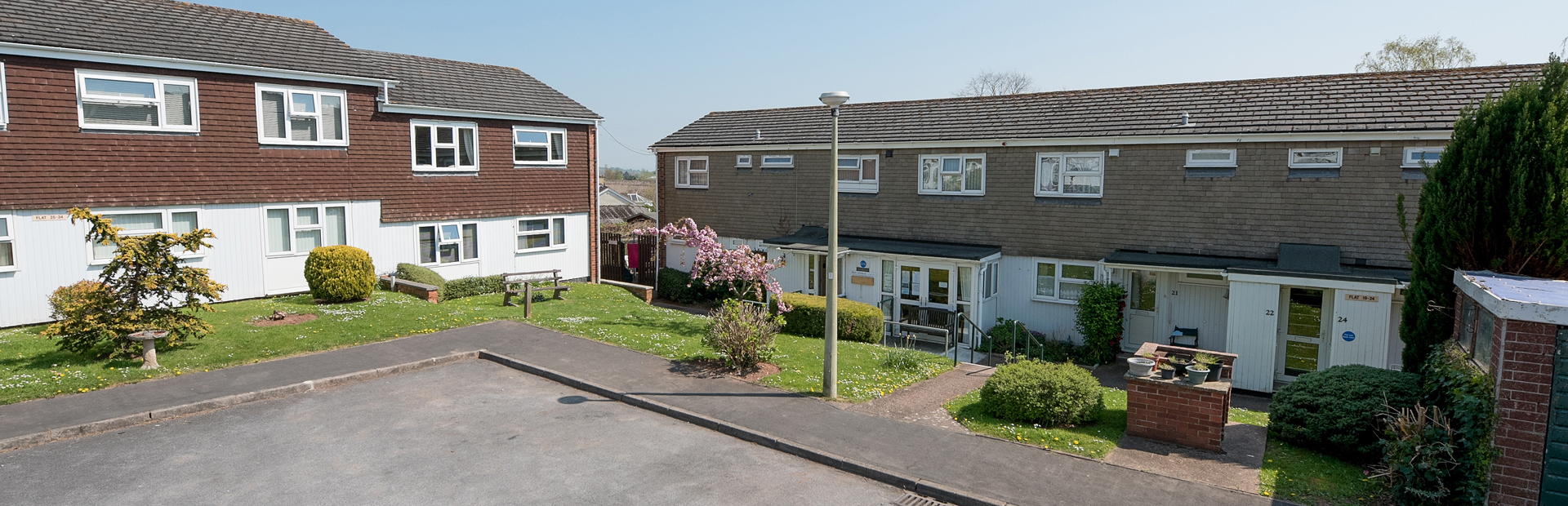 Front of the apartments and parking area with grassed frontage