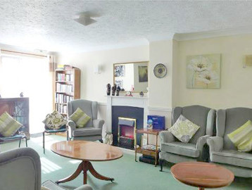 Communal lounge area with soft seating, coffee tables and a fireplace