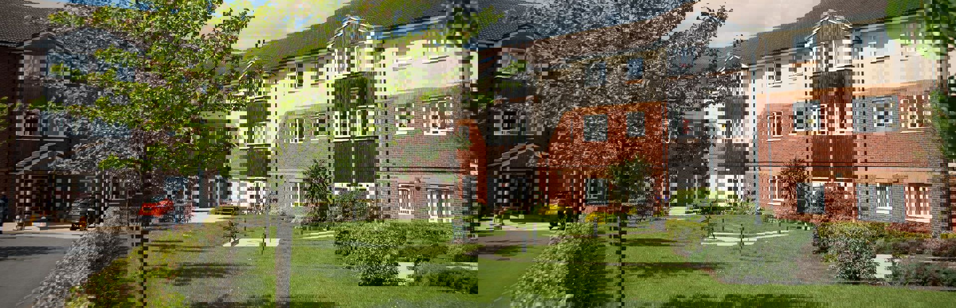 Front garden and entrance with trees and hedgerow leading up to the doorway