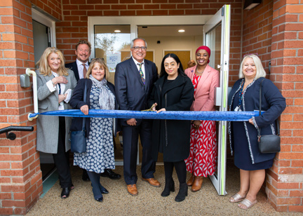 Colleagues and board members cutting the ribbon outside of a Housing 21 scheme