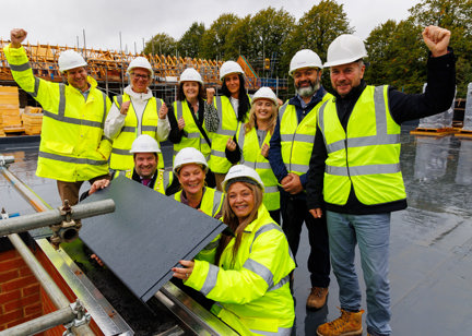 Housing 21 with partners pictured standing on the roof of a new development