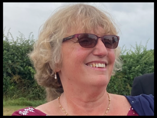 Resident Board Member Elizabeth (Anne) Golledge looks into the distance and smiles