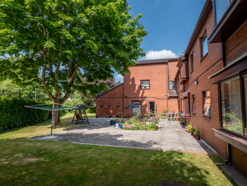 William Griffiths Court External gardens, a tree, flowerbeds, potted plants and seating