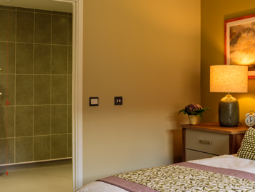 Inside the show home bedroom looking through to the bathroom from the bottom of the double bed