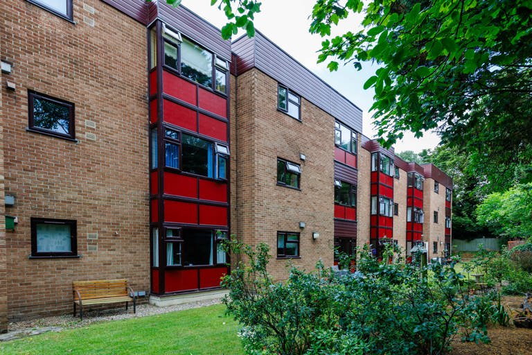 Exterior of Hildesley Court showing the brick building from the garden with greenery