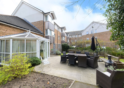 Patio area outside of the conservatory with large garden furniture set and parasol umbrella
