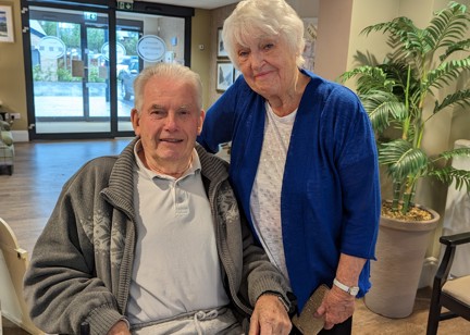 Residents Valerie and Peter smiling in a lobby area. 