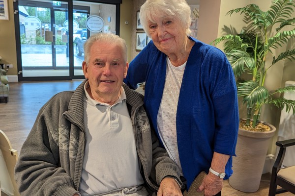 Residents Valerie and Peter smiling in a lobby area. 
