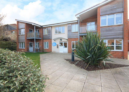 The main entrance of Alfred Deller Court with large grassed plant and slabbed area