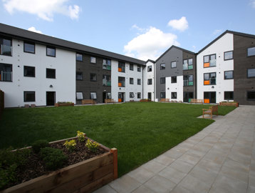 Large garden area with planters and benches around a grassed area