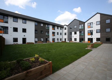 Large garden area with planters and benches around a grassed area