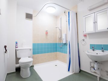 An accessible bathroom in an apartment with walk-in shower