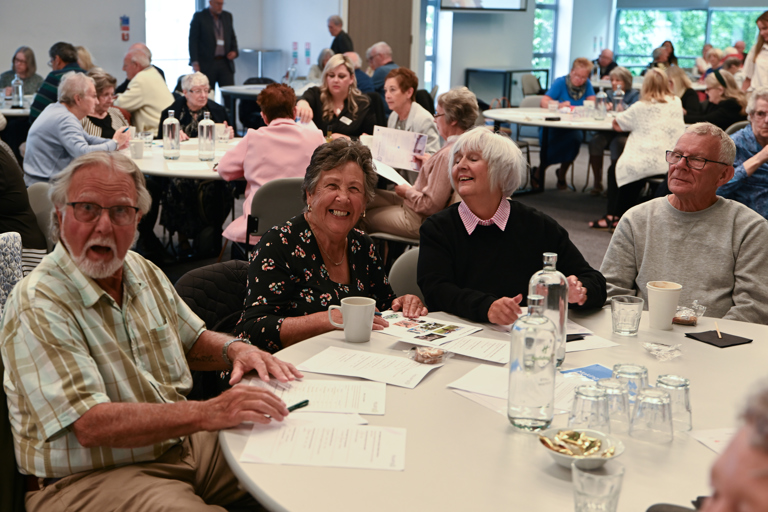 A table shot of four residents smiling and looking happy while doing a quiz