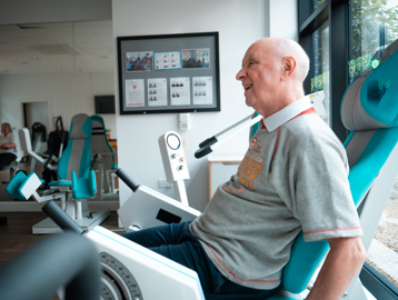 A male resident sat in a leg exercise machine in the on-site gym at Lime Gardens