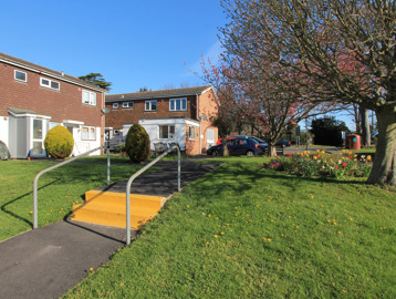 Two small steps leading up to the communal garden at the front of the scheme