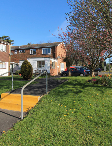 Two small steps leading up to the communal garden at the front of the scheme 