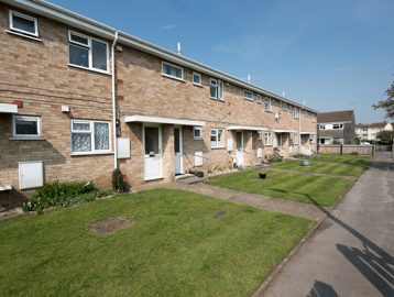 A row of gardens in front of resident's homes on a sunny day