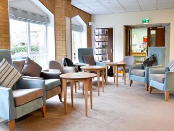Armchairs and tables in lounge at Alan Hilton Court