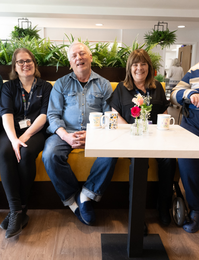 Four residents with the Local Manager, sat posing for the camera in the communal lounge 
