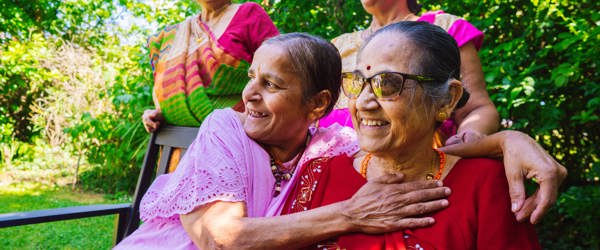 Four residents sitting in a garden smiling 