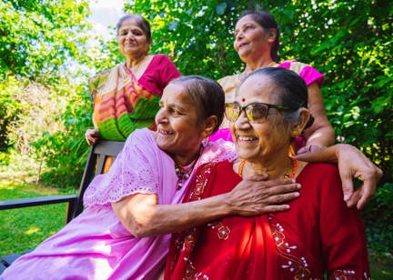 Four residents sitting in a garden smiling