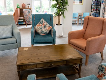 Bright and airy communal lounge with comfy chairs and coffee table