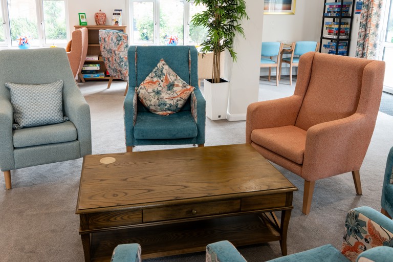 Bright and airy communal lounge with comfy chairs and coffee table