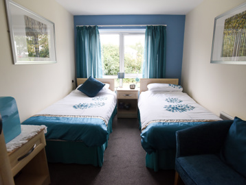 Guest room with twin beds in a blue and white colour scheme