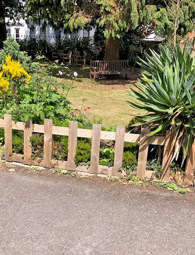 Short picket fence along the front of the communal garden with plants and flowers 