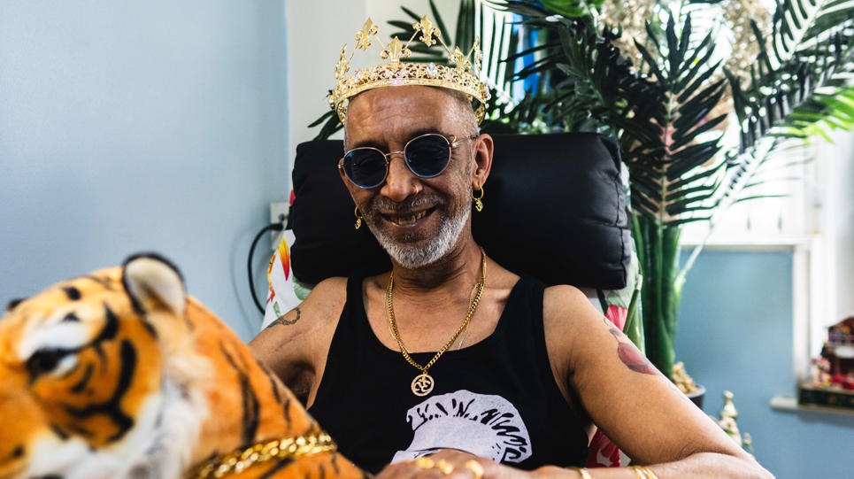 Resident smiling with a crown on holding a tiger teddy 